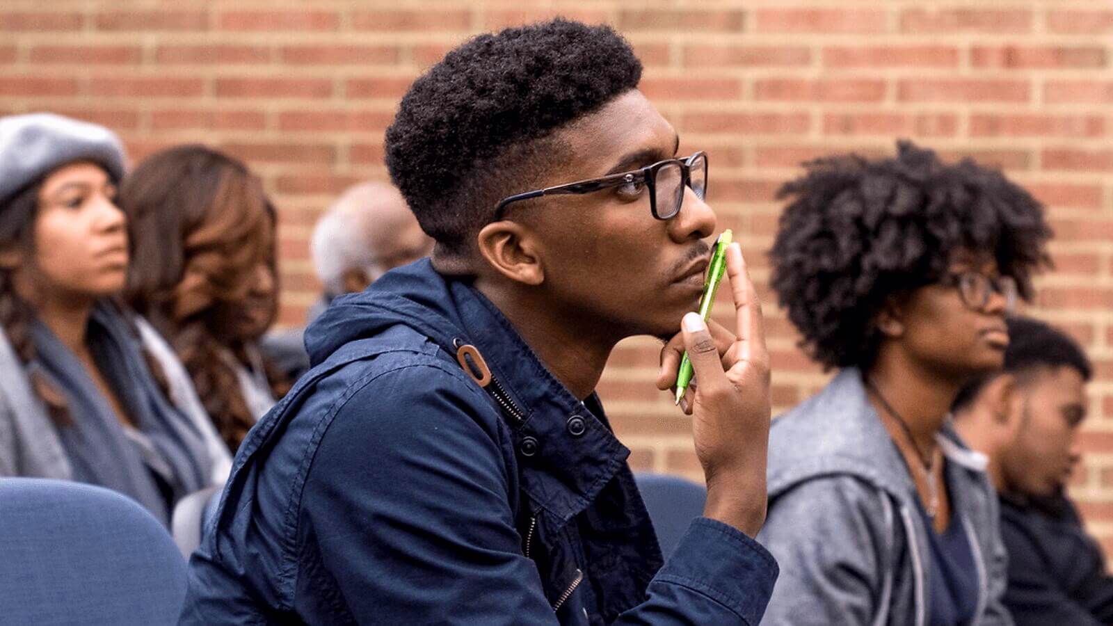 student sitting at an event listening 