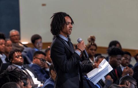 Student standing up at an event speaking