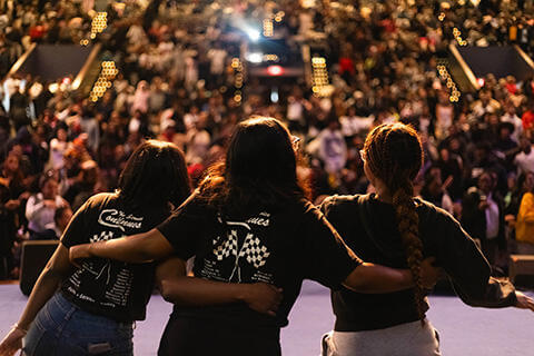 Students embracing on stage at a heartwarming event